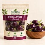 Fresh whole purple brinjal baingan in ceramic bowl on cream background